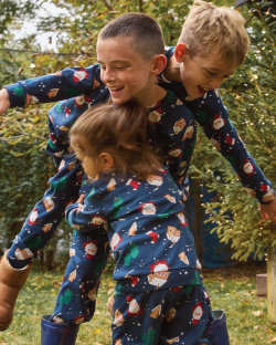 Dječaci u  novogodišnjim pidžamama se igrajaju u dvorištu